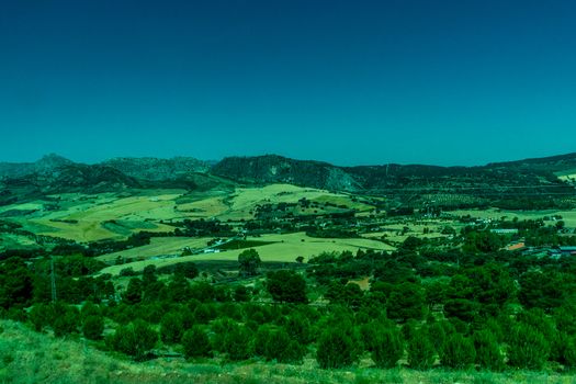 Greenery, Mountains, Farms and Fields on the outskirts of Ronda Spain, Europe on a hot summer day with clear blue skies