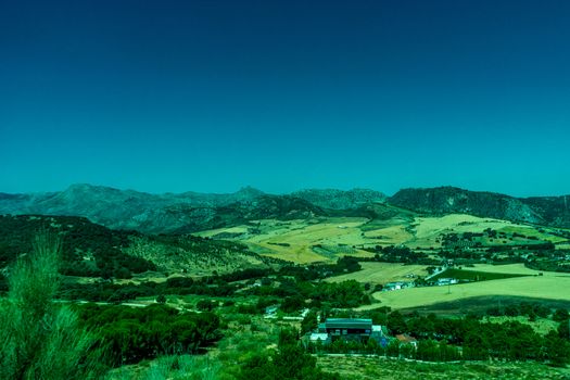 Greenery, Mountains, Farms and Fields on the outskirts of Ronda Spain, Europe on a hot summer day with clear blue skies