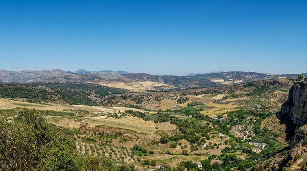 Greenery, Mountains, Farms and Fields on the outskirts of Ronda Spain, Europe on a hot summer day with clear blue skies