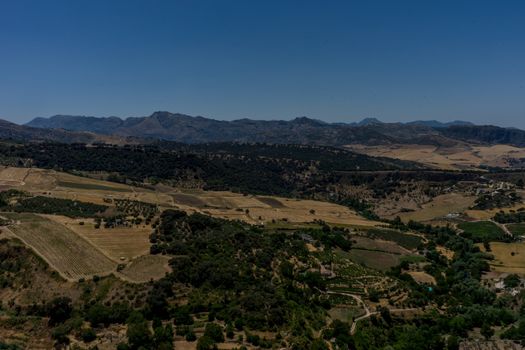 Greenery, Mountains, Farms and Fields on the outskirts of Ronda Spain, Europe on a hot summer day with clear blue skies