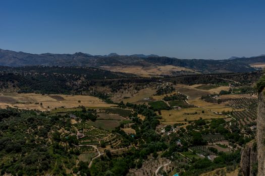 Greenery, Mountains, Farms and Fields on the outskirts of Ronda Spain, Europe on a hot summer day with clear blue skies