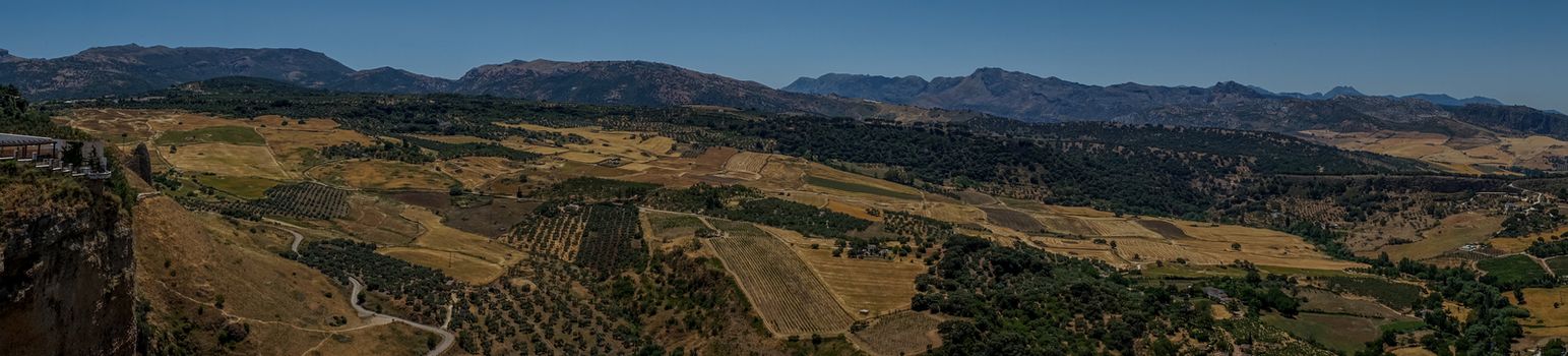 Panoramic view of Greenery, Mountains, Farms and Fields on the outskirts of Ronda Spain, Europe on a hot summer day with clear blue skies