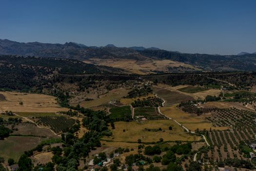 Greenery, Mountains, Farms and Fields on the outskirts of Ronda Spain, Europe on a hot summer day with clear blue skies