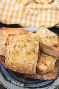 Traditional Portuguese bread toasted with virgin olive oil and oregano herbs on a shale stone.