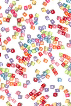 Colorful plastic beads with letters isolated on a white background.