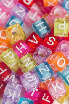 Colorful plastic beads with letters isolated on a white background.