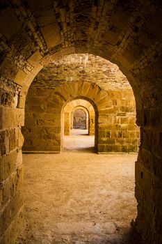 Italy - Old castle of Syracuse in Siciliy. Archs made of stone in perspective.