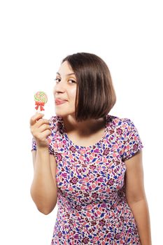 happy girl in pink dress trying to lick a spiral lollipop
