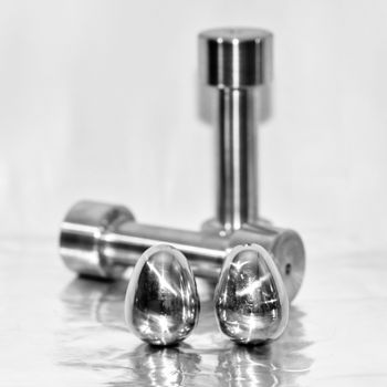 Metal dumbbells and steel eggs, the concept of sports training and the achievement of muscle strength.