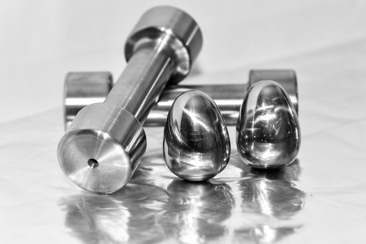 Metal dumbbells and steel eggs, the concept of sports training and the achievement of muscle strength.