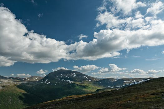 Panoramic mountains view with blue sky and white clouds in Norway