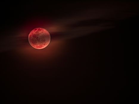 Bloodmoon or red moon,a natural phenomenon,with cloud on dark sky