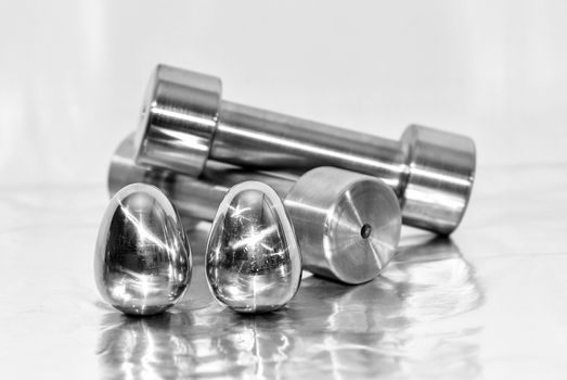 Metal dumbbells and steel eggs, the concept of sports training and the achievement of muscle strength.