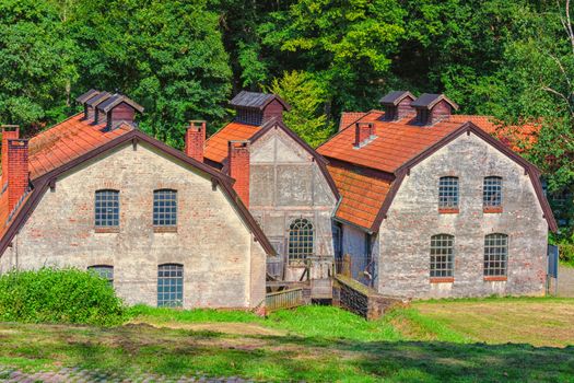 Large old abandoned factory building of a blacksmith and watermill