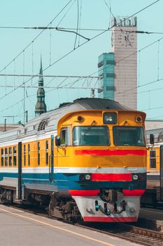 Old yellow passenger diesel train moving at the terminal