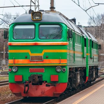 Green diesel cargo locomotive. Freight train in action