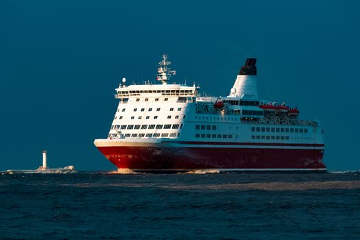 Red cruise liner. Passenger ship sailing from the sea in the morning