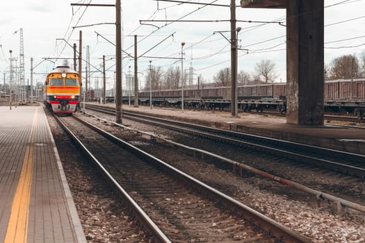 Old yellow passenger diesel train moving at the terminal