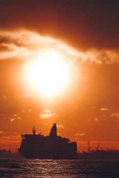 Hot orange winter sunrise against the cargo port