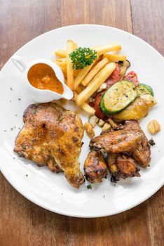 grilled chicken peri peri, BBQ Portuguese groumet griled cuisine, with fries and grilled vegetable.