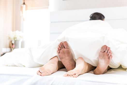 young sexy couples in love lying in bed in hotel, embracing on white sheets, close up legs, romantic mood