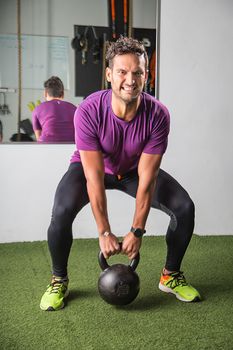 Young man pulling on a heavy kettlebell