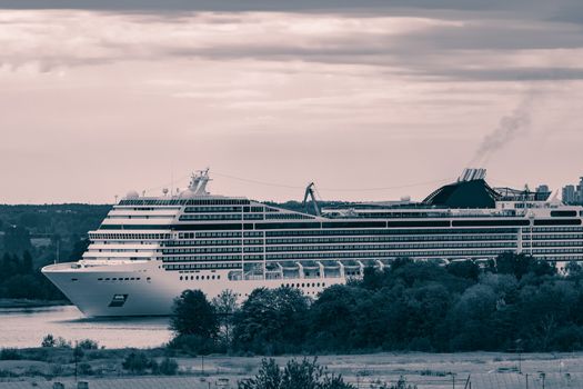 Large cruise liner sailing past the cargo port. Monochrome