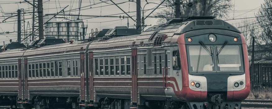 Red diesel passenger train driving at the old terminal