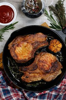 Roasted pork loin steak in a frying pan with tomato sauce and spices