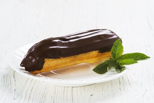 Eclairs on plate on a table on light background