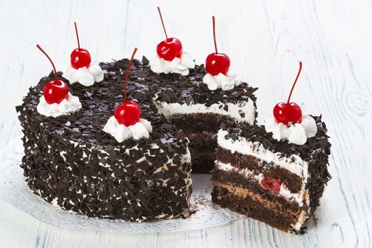 Chocolate cake with cherry on light background