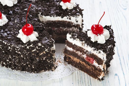 Chocolate cake with cherry on light background