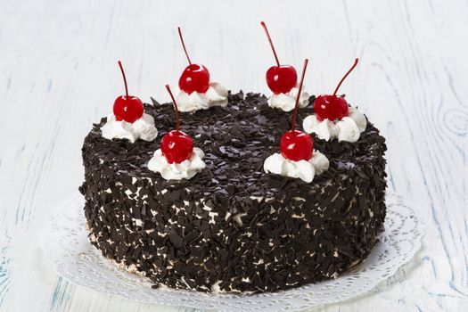 Chocolate cake with cherry on light background