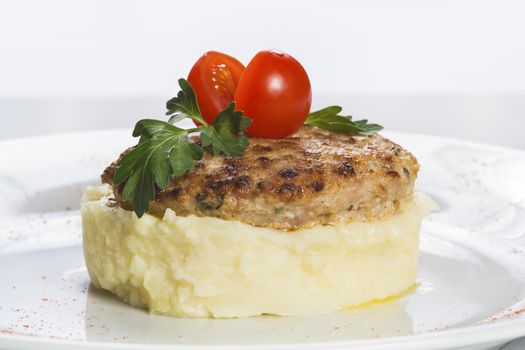 Cutlets with mashed potatoes decorated tomato