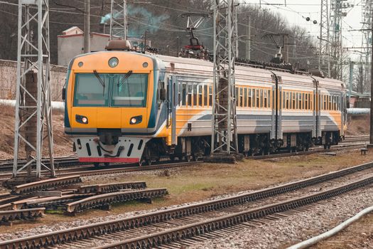 Yellow modern passenger electric train moving at the old terminal