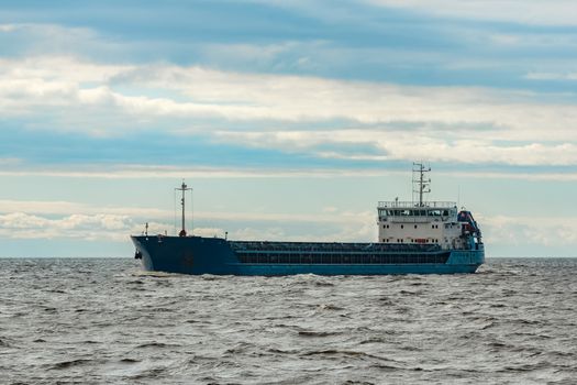 Merchandise import. Large blue cargo ship moving to Riga port