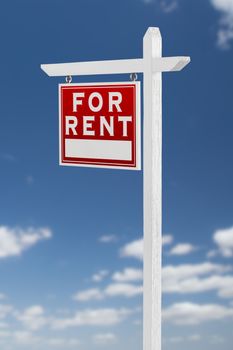 Left Facing For Rent Real Estate Sign on a Blue Sky with Clouds.