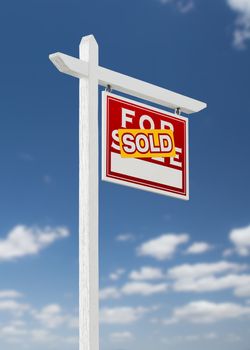 Right Facing Sold For Sale Real Estate Sign on a Blue Sky with Clouds.