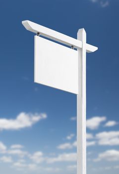 Blank Real Estate Sign Over A Blue Sky with Clouds.