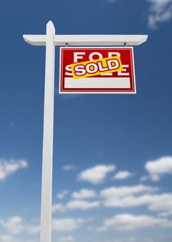 Right Facing Sold For Sale Real Estate Sign on a Blue Sky with Clouds.