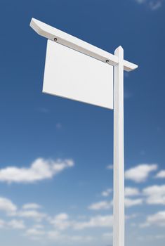 Blank Real Estate Sign Over A Blue Sky with Clouds.