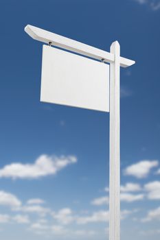 Blank Real Estate Sign Over A Blue Sky with Clouds.