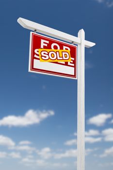 Left Facing Sold For Sale Real Estate Sign on a Blue Sky with Clouds.