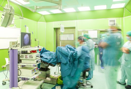 Motion blurred figures of doctors, performing an urology operation in a modern hospital surgery.
