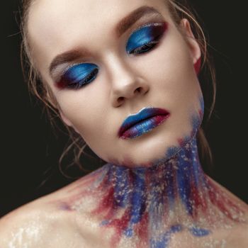 Studio Portrait of a young model girl with stylish makeup in a dark blue tones