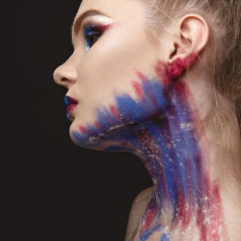 Studio Portrait of a young model girl with stylish makeup in a dark blue tones