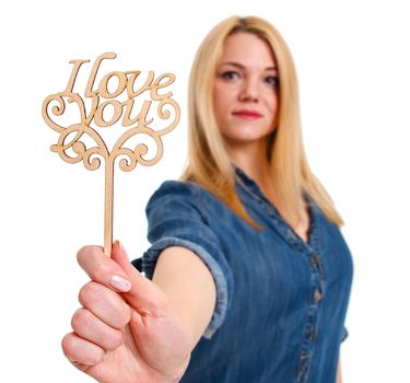 Young woman holding a sign "I love you" in hand. Valentine day concept.