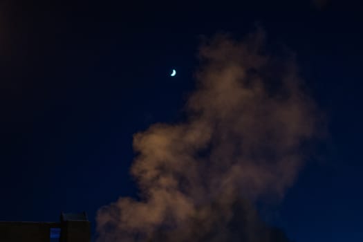the moon and smoke a winter evening in the city of Nizhnevartovsk