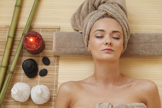 Beautiful young woman relaxing in spa salon