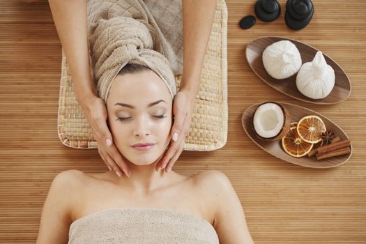 Beautiful young woman relaxing in spa salon